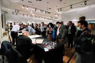 A crowd of people gathered at an art gallery in Mensing, Germany