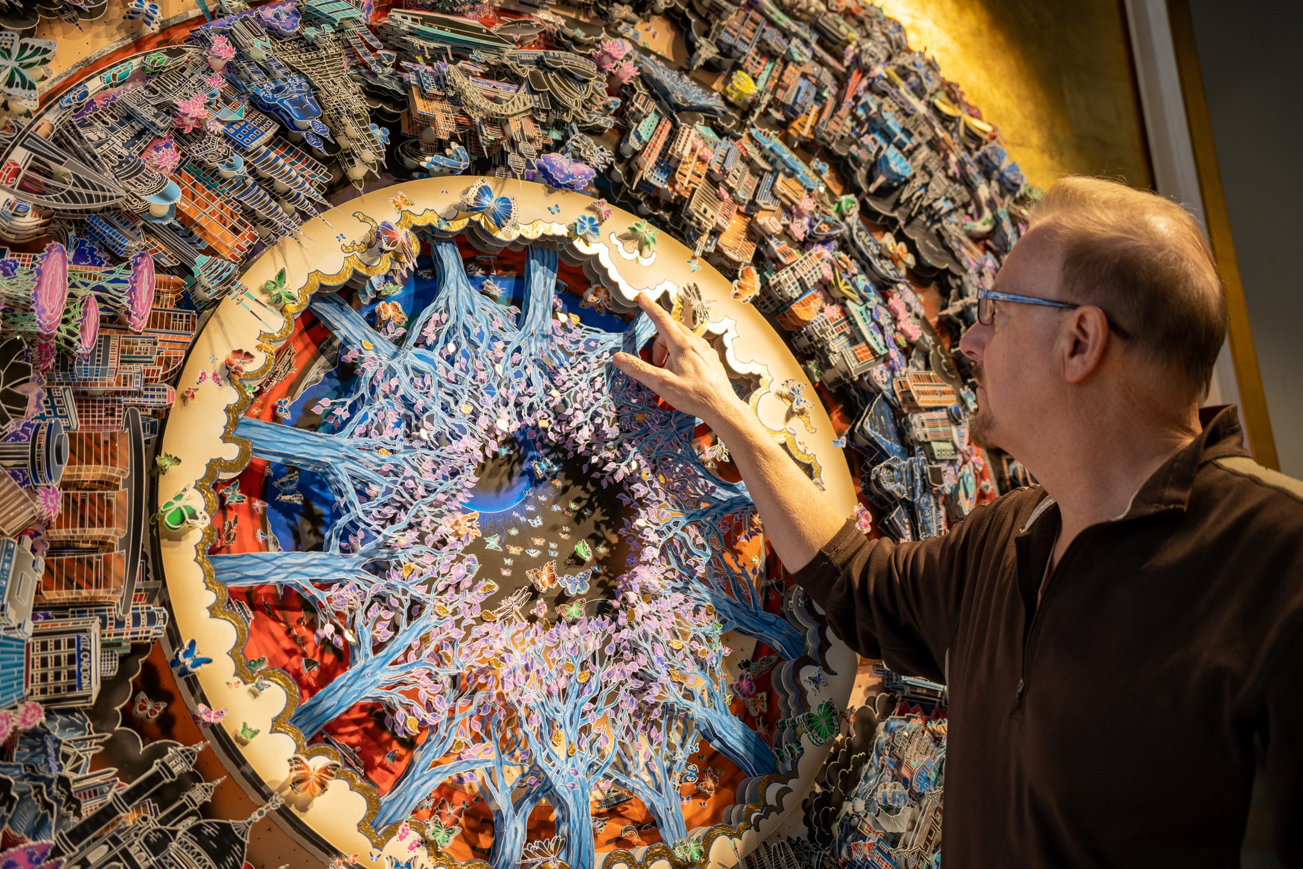 Charles puts his hand on the 3D pop artwork One World which features cityscape from around the globe coated in beautiful gold details