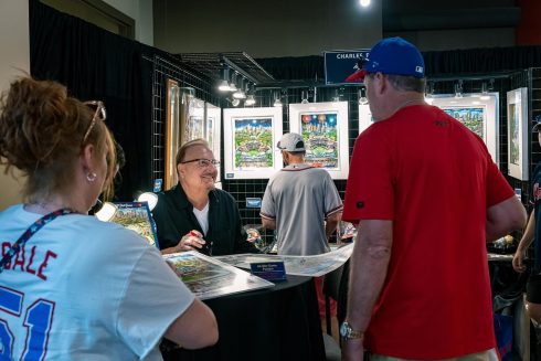 People gather around the Fazzino booth at the All-Star Village