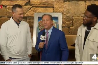 Bruce Beck interviewing Yankees manager Aaron Boone and Giants running back Tyron Tracy standing in front of Fazzino's artwork for the SBH Health System unveiling