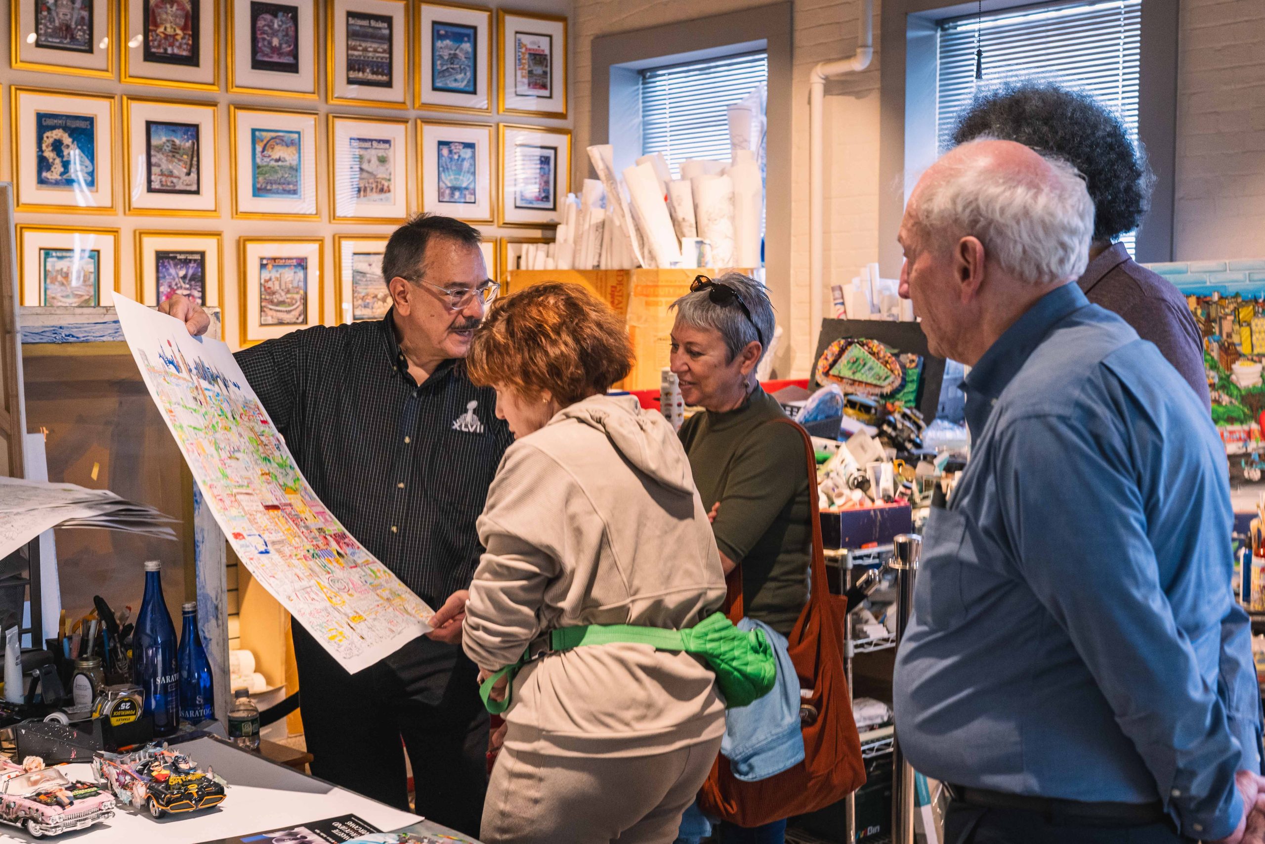 A group of people gather to look more closely at Fazzino artwork and how it gets created