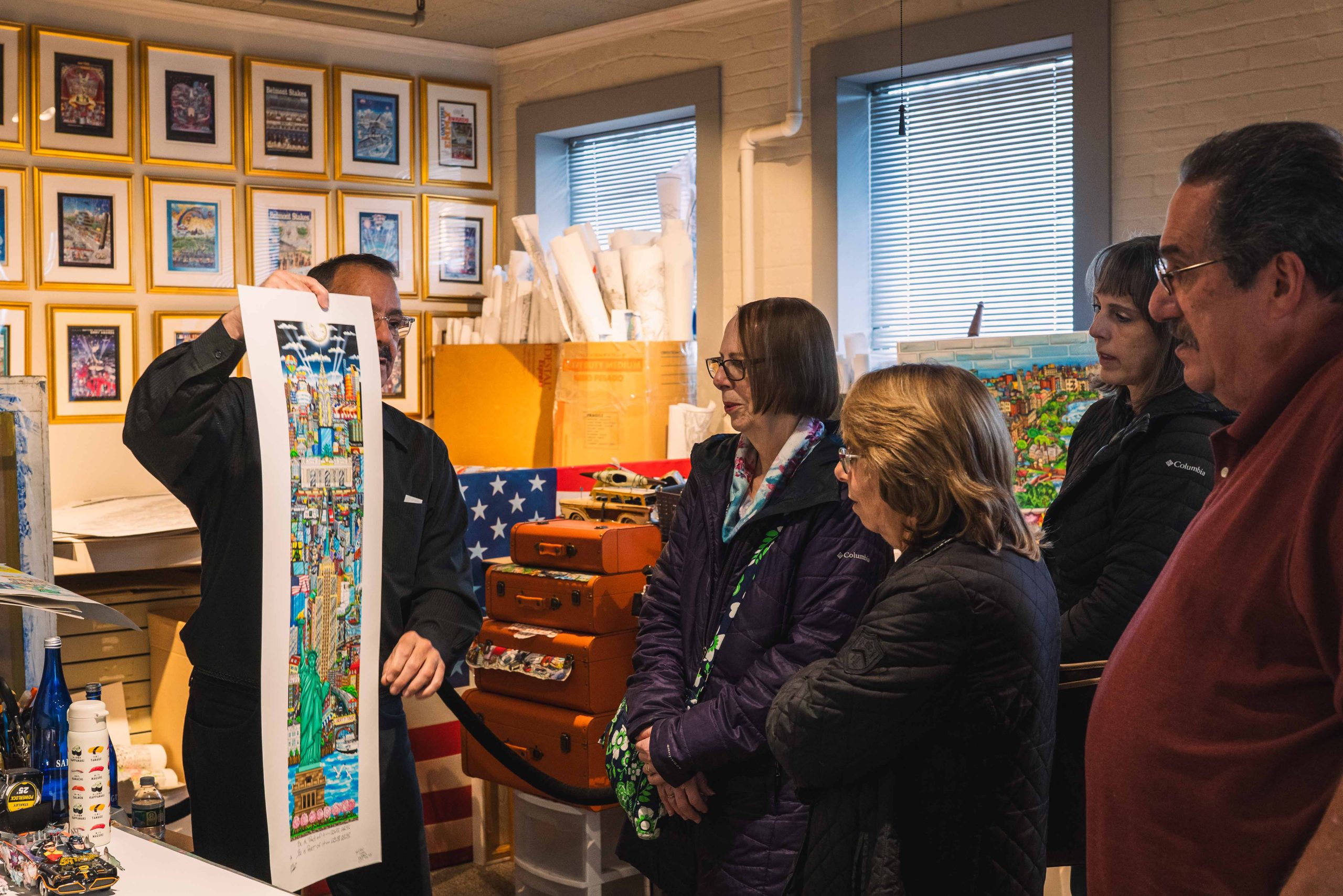 A group of people attending ArtsFest look closely at Fazzino artwork to see how it gets created