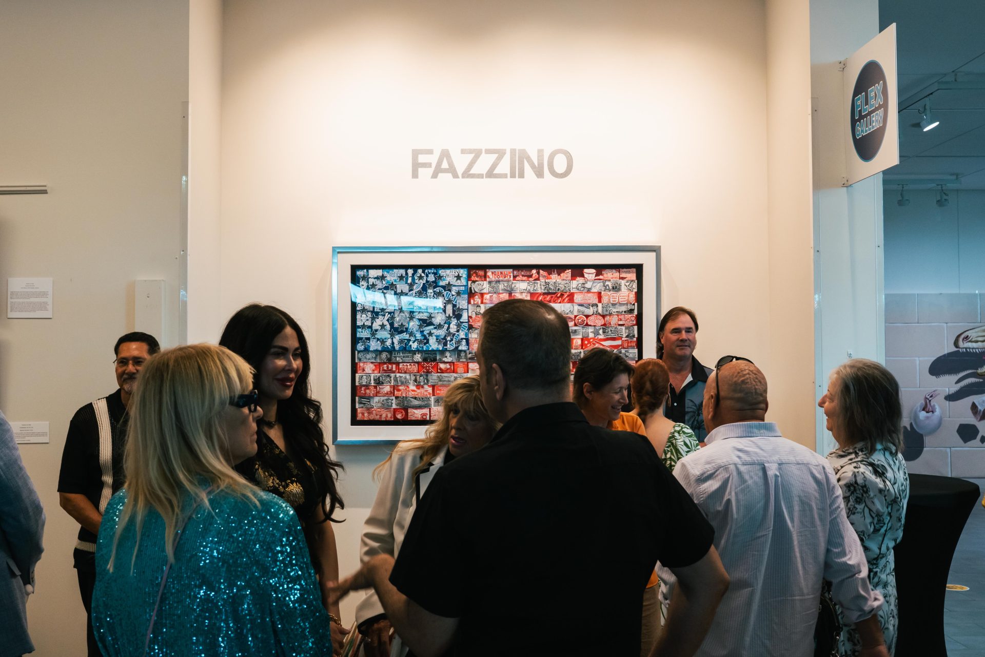 A group of people gather in front of Fazzino's America flag artwork to see the retrospective at the Elliot Museum