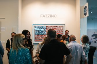 A group of people gather in front of Fazzino's America flag artwork to see the retrospective at the Elliot Museum