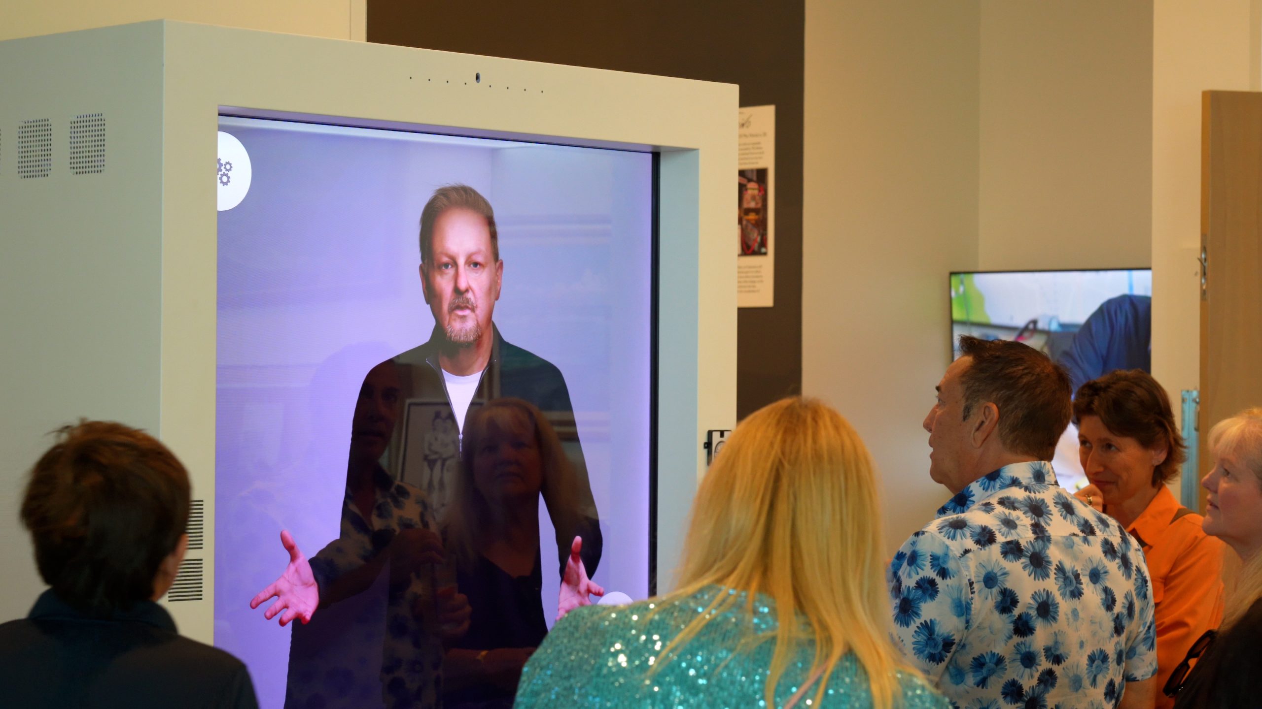 Fazzino on the wall of the gallery talks to gallery viewers about his artwork